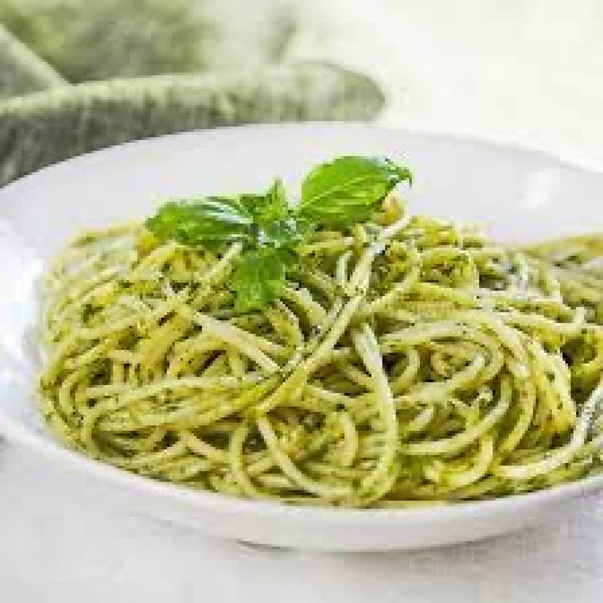 Spaghetti en salsa pesto parmesano con tiras de pechuga